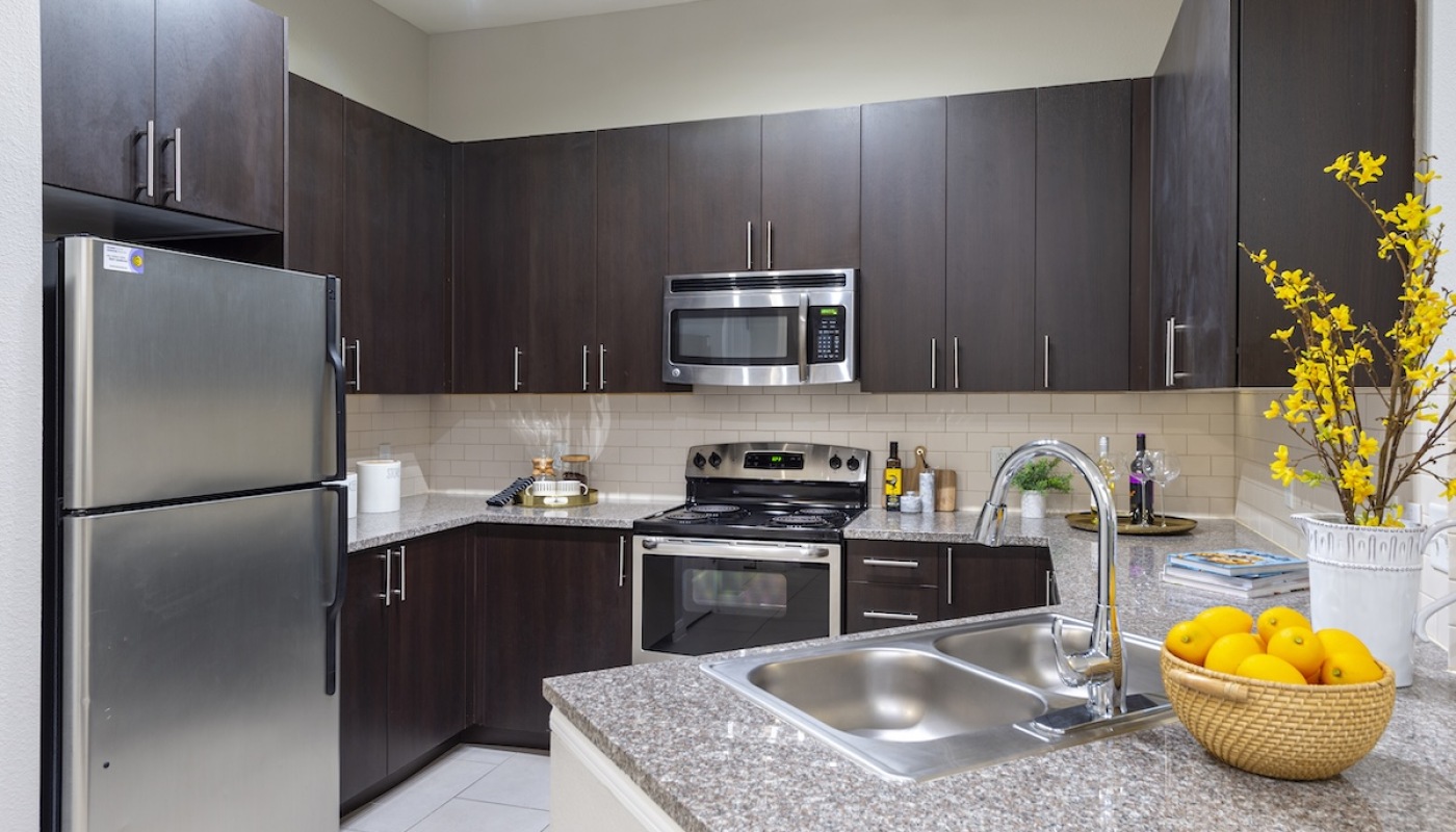 Large well lit kitchen with stainless steel appliances