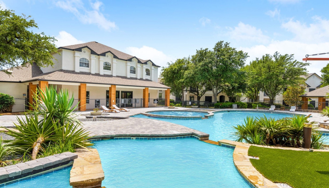 a courtyard with a large pool and a building next to it