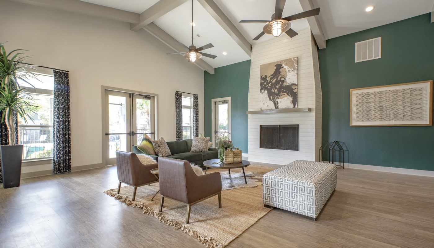 Spacious well lit lounge area with wood floors and a fireplace