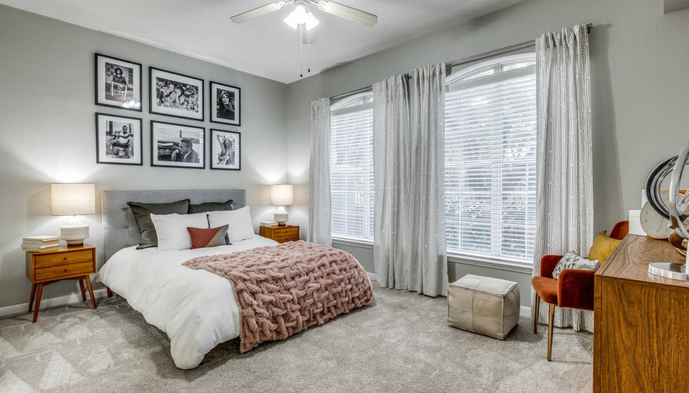 spacious, carpeted bedroom with large windows